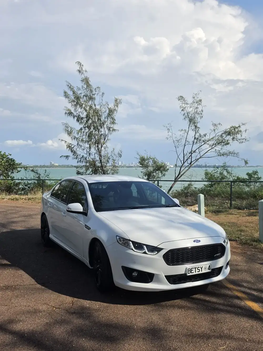 White performance sedan, front three-quarter view